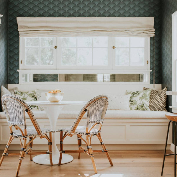 A home sitting room decorated with richly textured, dark green wallpaper