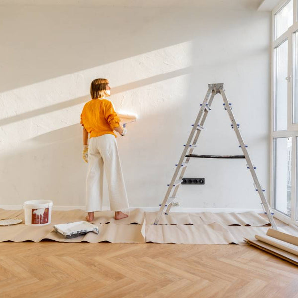 Woman painting a white wall in an empty apartment at Hoover Paint near Nashville, TN