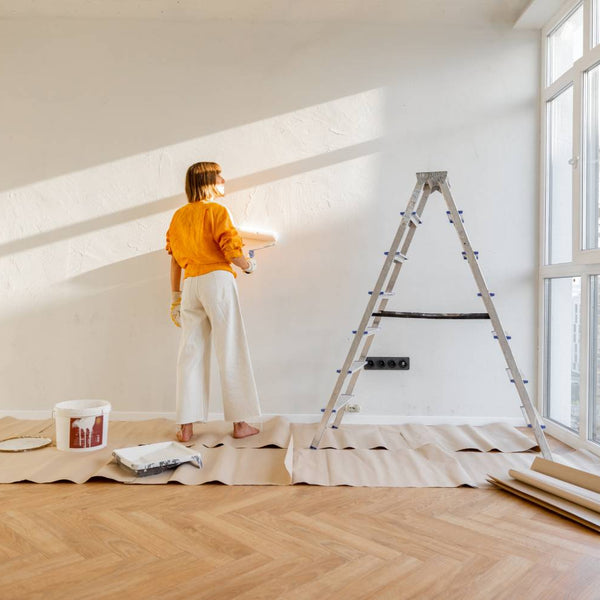 Woman painting a white wall in an empty apartment at Hoover Paint near Nashville, TN