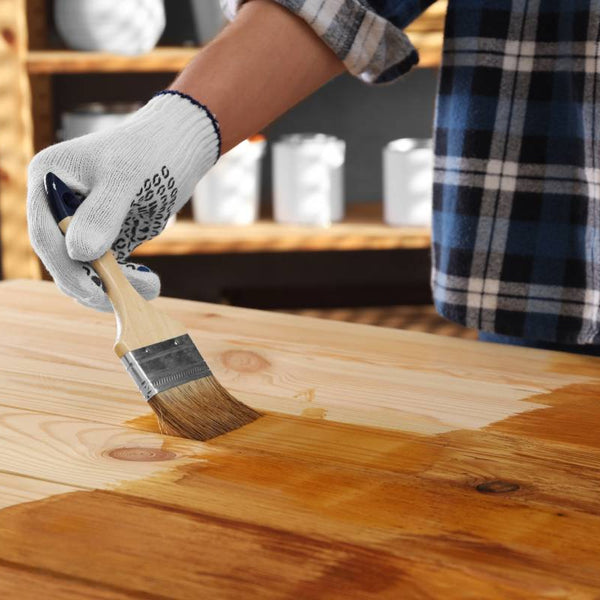 Person applying wood stain to a wooden table