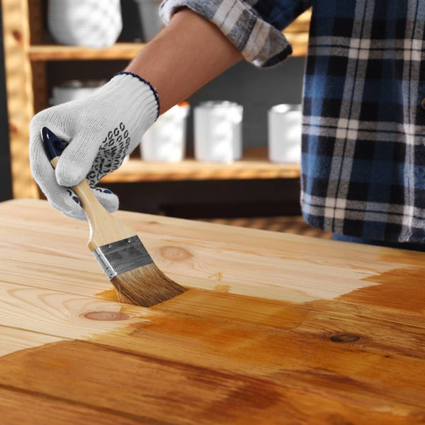 Person applying wood stain to a wooden table