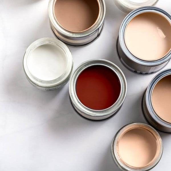 A collection of about seven opened neutral interior paint cans on a white background at Hoover Paint near Central Tennessee